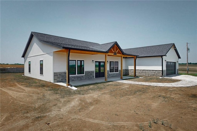 350 NW 1201st Rd, Holden, MO 64040 - view of front of property featuring stone siding, a garage, driveway, and french doors