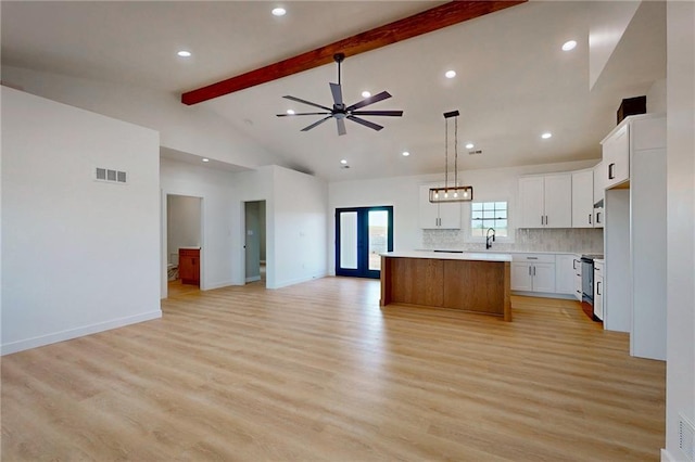 350 NW 1201st Rd, Holden, MO 64040 - kitchen with open floor plan, beam ceiling, light countertops, a kitchen island, and stainless steel electric range oven