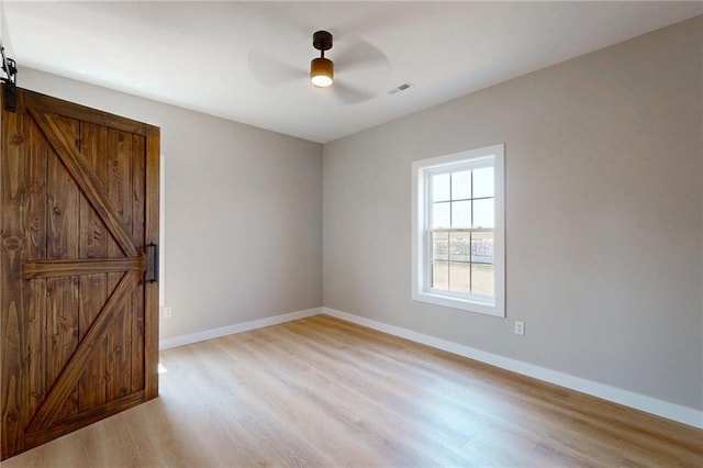 350 NW 1201st Rd, Holden, MO 64040 - spare room with a barn door, light wood finished floors, and a ceiling fan