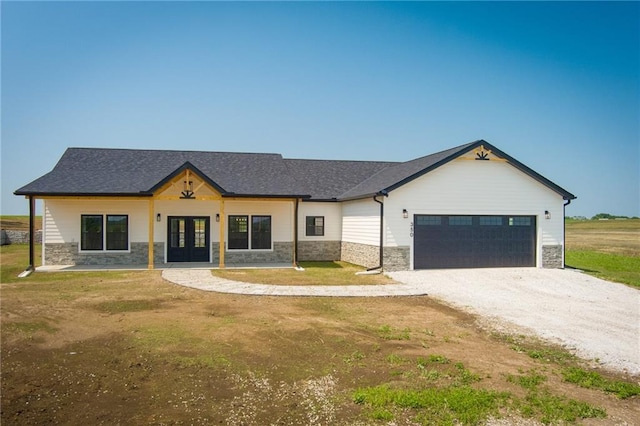350 NW 1201st Rd, Holden, MO 64040 - modern farmhouse with french doors, stone siding, a garage, driveway, and a front lawn