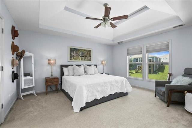 600 SW Gentry Ln, Lees Summit, MO 64081 - bedroom featuring a tray ceiling, light carpet, and a ceiling fan