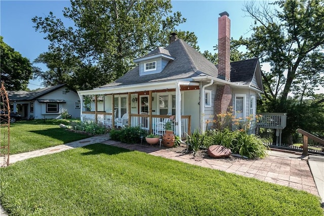 421 N Nettleton Ave, Bonner Springs, KS 66012 - bungalow-style house with covered porch, a front yard, a chimney, and a shingled roof
