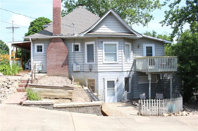 421 N Nettleton Ave, Bonner Springs, KS 66012 - rear view of property featuring a balcony, a chimney, and a shingled roof