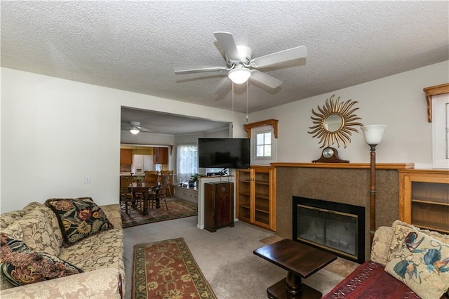 421 N Nettleton Ave, Bonner Springs, KS 66012 - living area with ceiling fan, a tile fireplace, a textured ceiling, and carpet floors