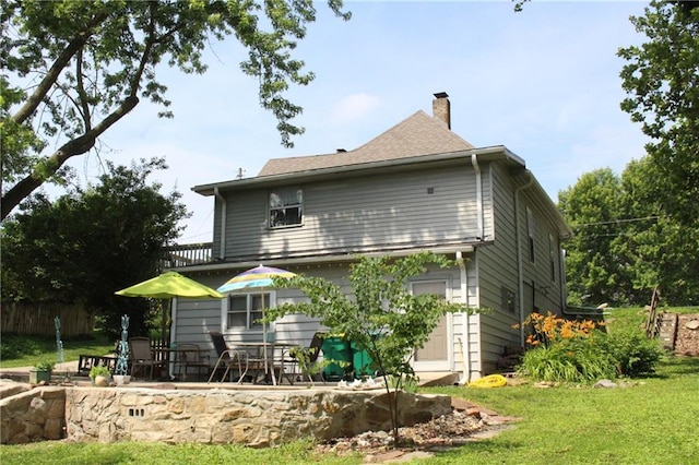 421 N Nettleton Ave, Bonner Springs, KS 66012 - rear view of house featuring a chimney and a patio area