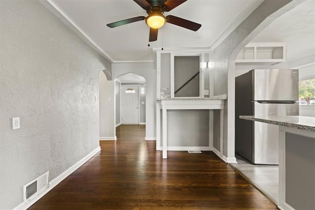 13623 W 95th St, Lenexa, KS 66215 - unfurnished living room featuring a textured wall, arched walkways, wood finished floors, ceiling fan, and crown molding