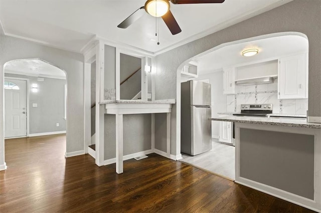 13623 W 95th St, Lenexa, KS 66215 - kitchen with stainless steel appliances, arched walkways, a ceiling fan, wood finished floors, and white cabinets