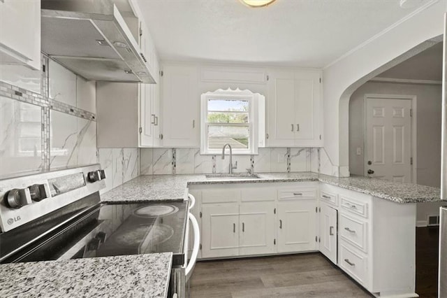 13623 W 95th St, Lenexa, KS 66215 - kitchen with stainless steel electric range oven, wall chimney exhaust hood, white cabinets, a peninsula, and decorative backsplash