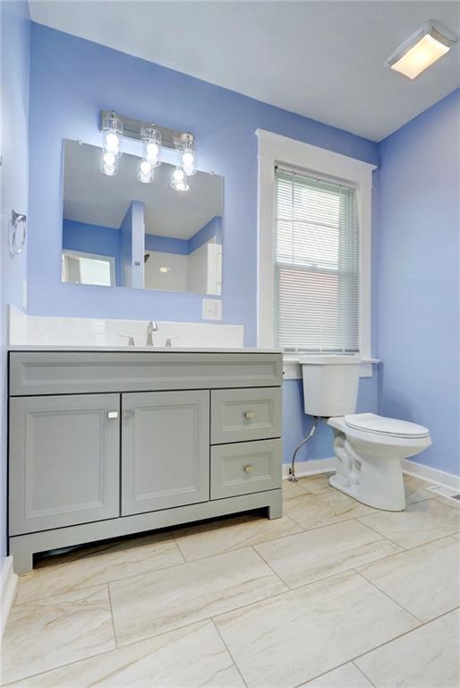 3521 Windsor Ave, Kansas City, MO 64123 - bathroom with toilet, baseboards, and vanity