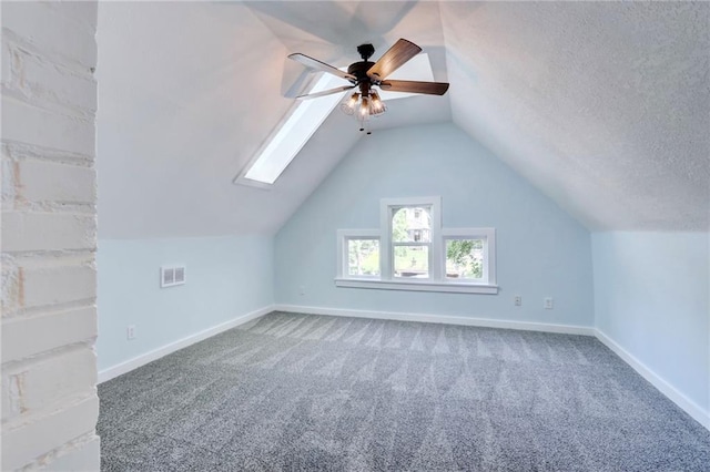 3521 Windsor Ave, Kansas City, MO 64123 - additional living space featuring ceiling fan, carpet flooring, baseboards, a skylight, and lofted ceiling