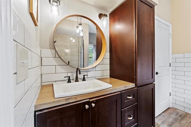 115 Adkins Rd, Glenaire, MO 64068 - full bath featuring tile walls, vanity, wood finished floors, and backsplash