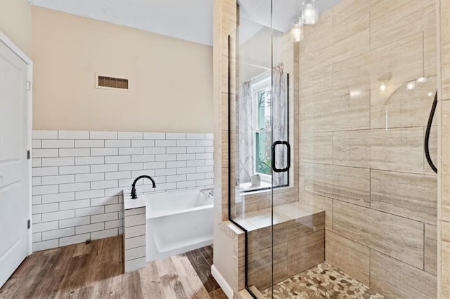 115 Adkins Rd, Glenaire, MO 64068 - full bath with a freestanding tub, a stall shower, wood finished floors, and tile walls
