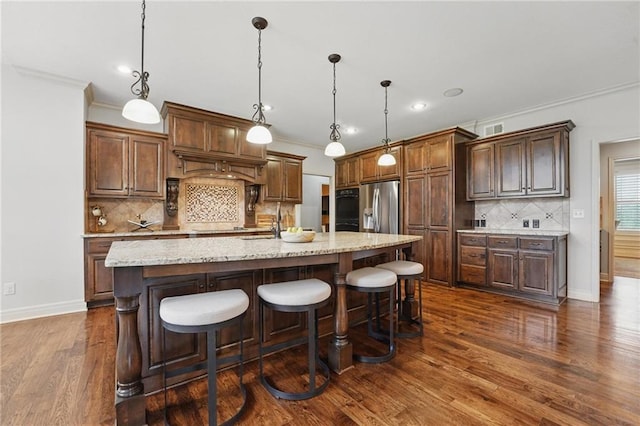 9332 W 158th St, Overland Park, KS 66221 - kitchen featuring stainless steel refrigerator with ice dispenser, backsplash, crown molding, dark wood-style floors, and a center island with sink
