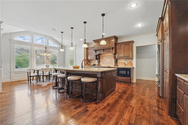 9332 W 158th St, Overland Park, KS 66221 - kitchen with a kitchen bar, black microwave, dark wood-style flooring, a kitchen island with sink, and recessed lighting