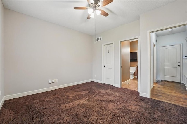 9332 W 158th St, Overland Park, KS 66221 - unfurnished bedroom with dark carpet, ensuite bath, and ceiling fan