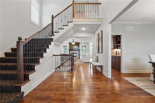 9332 W 158th St, Overland Park, KS 66221 - entryway featuring stairway, wood finished floors, crown molding, and a glass covered fireplace