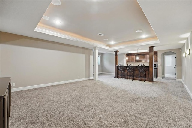 9332 W 158th St, Overland Park, KS 66221 - unfurnished living room featuring a tray ceiling, bar, light carpet, arched walkways, and recessed lighting
