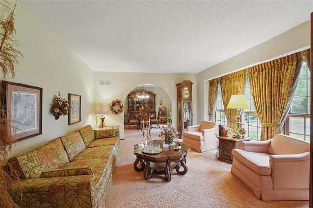 8206 Parkhill Cir, Lenexa, KS 66215 - living area with arched walkways, carpet, a textured ceiling, and healthy amount of natural light