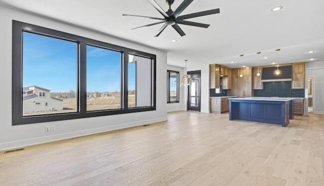 22076 W 99th Ter, Lenexa, KS 66220 - kitchen with recessed lighting, brown cabinetry, baseboards, light wood-style flooring, and pendant lighting