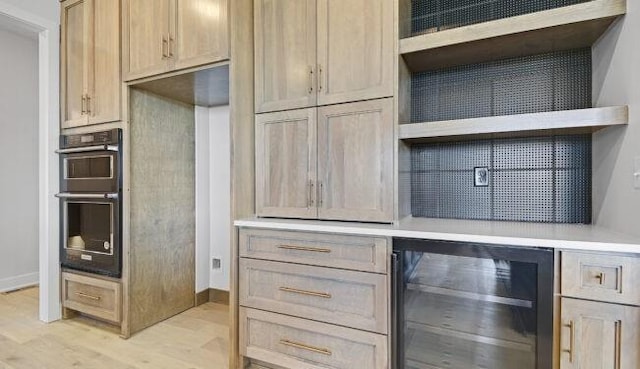 22076 W 99th Ter, Lenexa, KS 66220 - kitchen with wine cooler, light wood-type flooring, double oven, light countertops, and baseboards