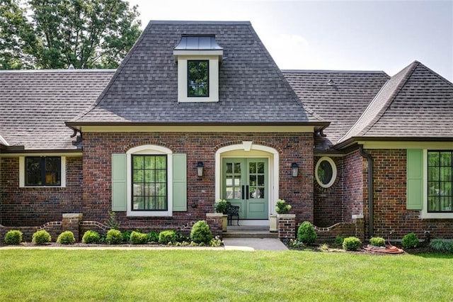8311 Wenonga Rd, Leawood, KS 66206 - view of front of home featuring roof with shingles, brick siding, a front yard, and french doors
