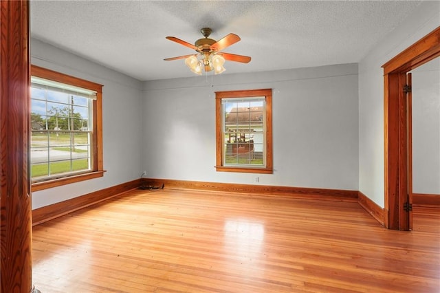 800 Brown Ave, Osawatomie, KS 66064 - spare room featuring healthy amount of natural light, light wood-style floors, a textured ceiling, and a ceiling fan