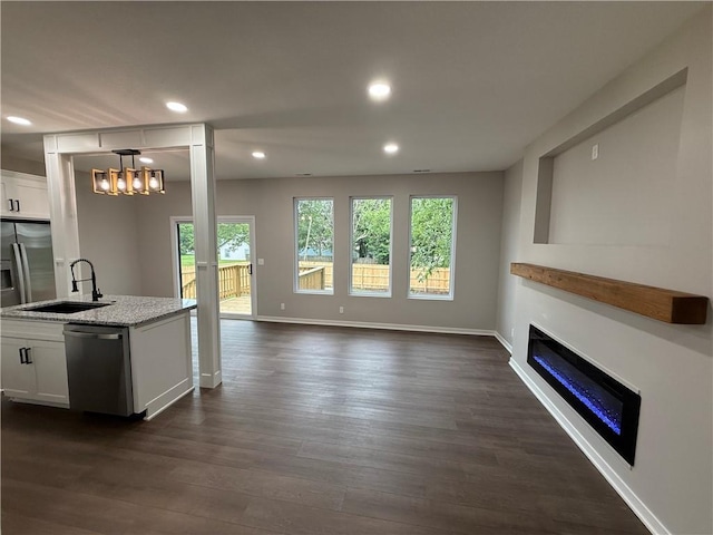 1141 Walnut Ave, Osawatomie, KS 66064 - living area featuring a glass covered fireplace, dark wood-style floors, recessed lighting, a chandelier, and baseboards
