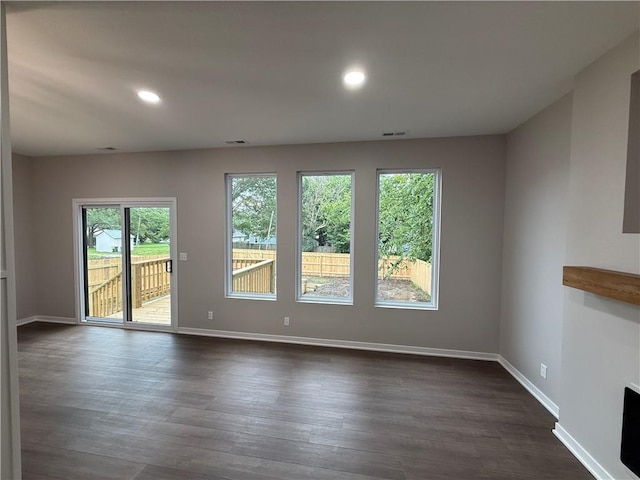 1141 Walnut Ave, Osawatomie, KS 66064 - unfurnished room with healthy amount of natural light, baseboards, dark wood-style floors, and recessed lighting