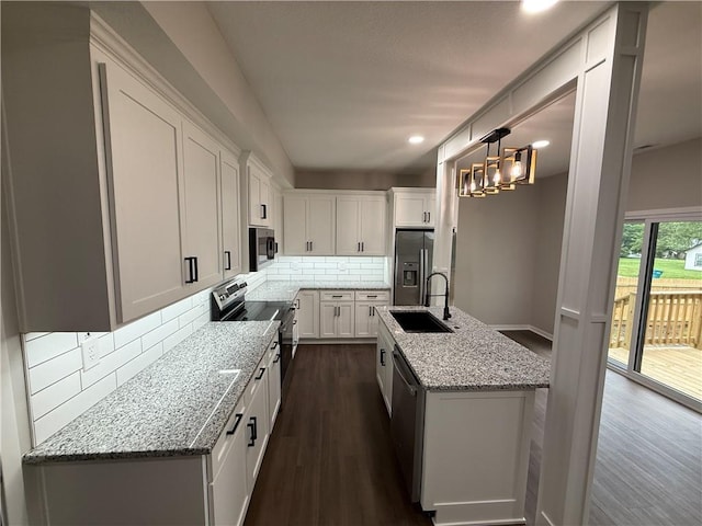 1141 Walnut Ave, Osawatomie, KS 66064 - kitchen featuring stainless steel appliances, a sink, dark wood-style floors, white cabinetry, and tasteful backsplash