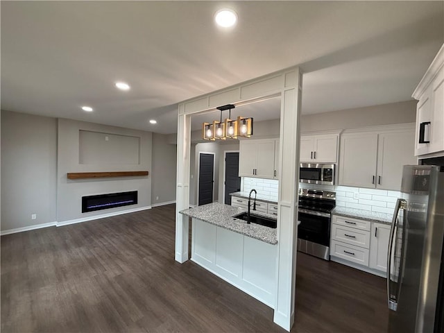1141 Walnut Ave, Osawatomie, KS 66064 - kitchen with appliances with stainless steel finishes, a sink, backsplash, white cabinets, and recessed lighting