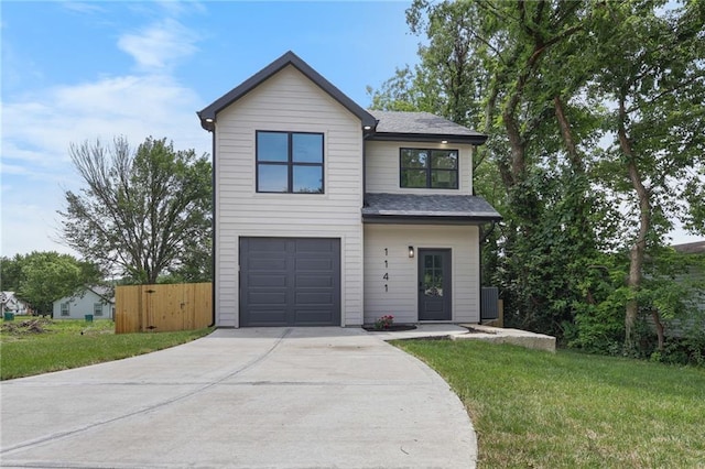 1141 Walnut Ave, Osawatomie, KS 66064 - view of front of home with an attached garage, concrete driveway, and roof with shingles