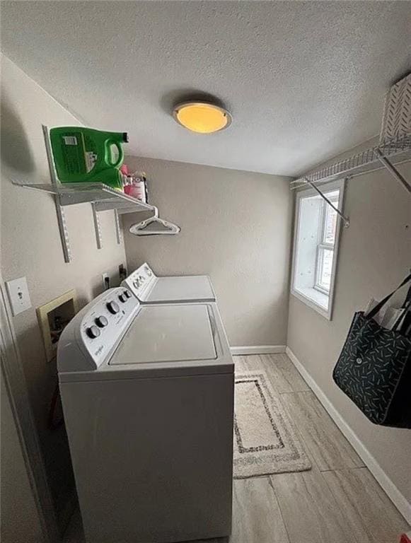 501 W Mcpherson St, Knob Noster, MO 65336 - laundry area with washing machine and clothes dryer, a textured ceiling, baseboards, and light wood-style flooring