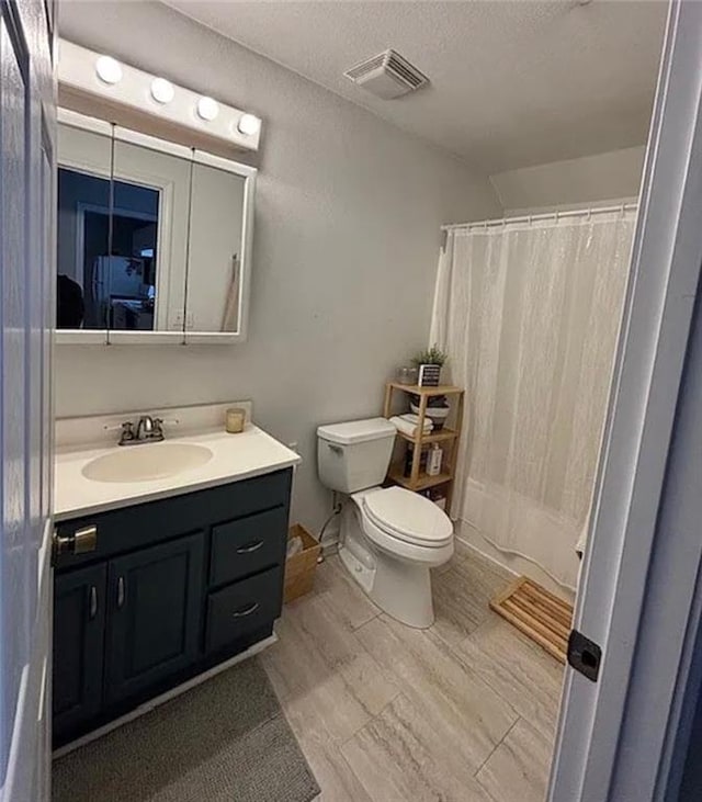 501 W Mcpherson St, Knob Noster, MO 65336 - bathroom featuring toilet, vanity, a textured ceiling, and shower / bath combination with curtain