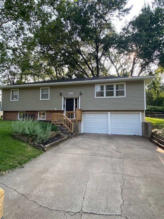 4820 Stearns Ln, Shawnee, KS 66203 - split foyer home featuring a garage and asphalt driveway