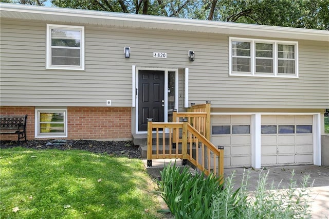 4820 Stearns Ln, Shawnee, KS 66203 - doorway to property with a garage, concrete driveway, and a yard