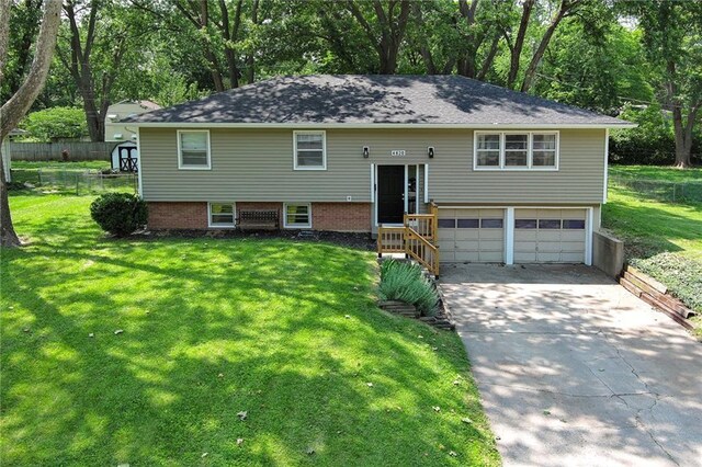 4820 Stearns Ln, Shawnee, KS 66203 - split foyer home featuring driveway, an attached garage, and view of wooded area