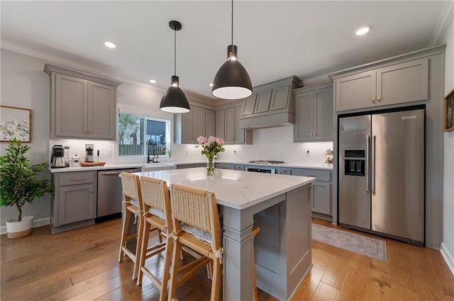 1505 SW Georgetown Dr, Lees Summit, MO 64082 - kitchen featuring appliances with stainless steel finishes, gray cabinetry, custom exhaust hood, crown molding, and tasteful backsplash