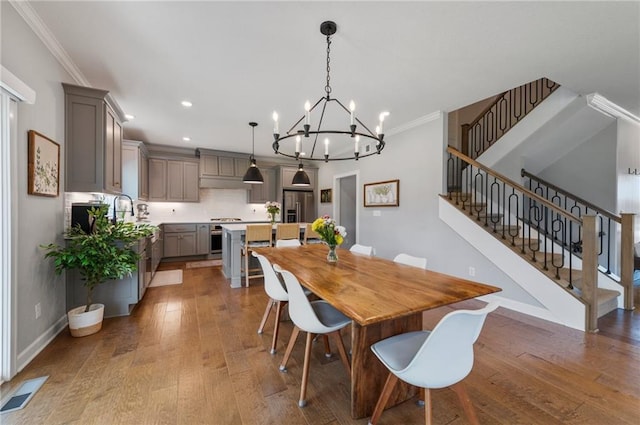 1505 SW Georgetown Dr, Lees Summit, MO 64082 - dining space featuring stairway, hardwood / wood-style flooring, crown molding, a chandelier, and recessed lighting
