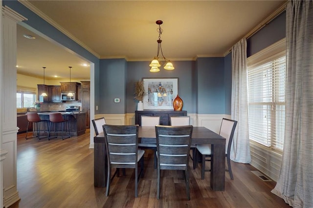 3201 SE 3rd St, Lees Summit, MO 64063 - dining area with dark wood-style floors, crown molding, a wainscoted wall, and a chandelier
