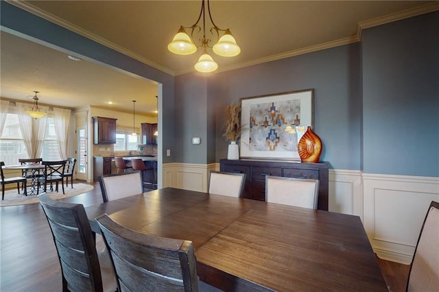 3201 SE 3rd St, Lees Summit, MO 64063 - dining area featuring a wainscoted wall, a chandelier, dark wood-style floors, a decorative wall, and crown molding
