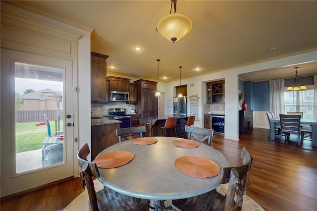3201 SE 3rd St, Lees Summit, MO 64063 - dining room featuring beverage cooler, dark wood-type flooring, crown molding, and recessed lighting