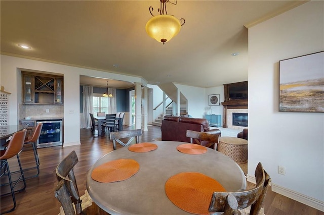 3201 SE 3rd St, Lees Summit, MO 64063 - dining room featuring wine cooler, a glass covered fireplace, stairs, and dark wood finished floors