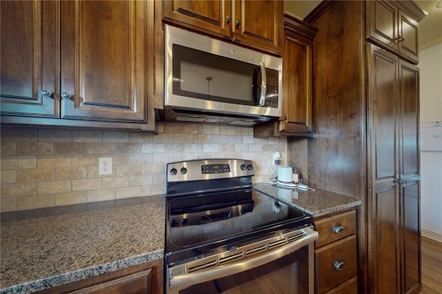 3201 SE 3rd St, Lees Summit, MO 64063 - kitchen with appliances with stainless steel finishes, decorative backsplash, and dark stone counters