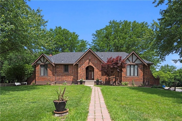 1504 NE Continental Cir, Lees Summit, MO 64086 - english style home with brick siding, a front yard, and a shingled roof