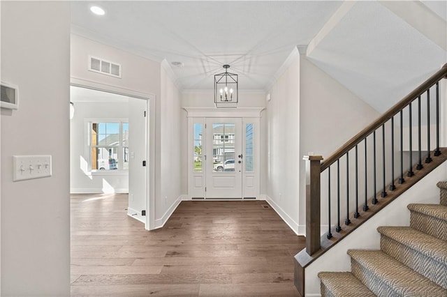 3117 SW Arbor Tree Dr, Lees Summit, MO 64082 - entryway featuring ornamental molding, plenty of natural light, wood finished floors, stairway, and a chandelier