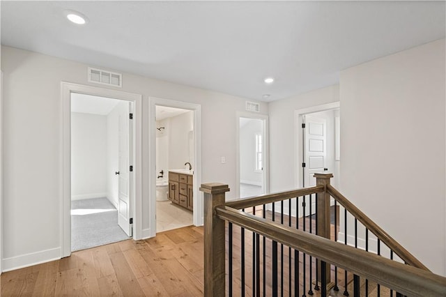 3117 SW Arbor Tree Dr, Lees Summit, MO 64082 - hall with an upstairs landing, light wood finished floors, recessed lighting, baseboards, and a sink
