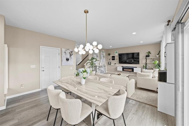 1420 SW Cornwall Rd, Lees Summit, MO 64083 - dining room with light wood-style floors, a chandelier, a lit fireplace, and recessed lighting