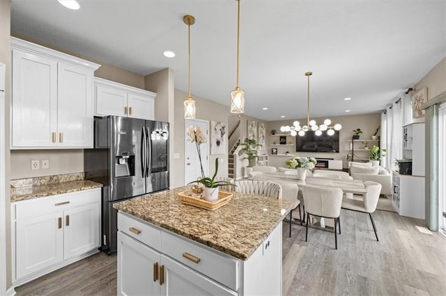 1420 SW Cornwall Rd, Lees Summit, MO 64083 - kitchen with stainless steel fridge with ice dispenser, light wood-type flooring, white cabinetry, a kitchen island, and light stone countertops