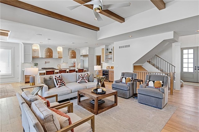 17029 King St, Overland Park, KS 66221 - living room featuring beamed ceiling, wine cooler, stairway, light wood finished floors, and ceiling fan