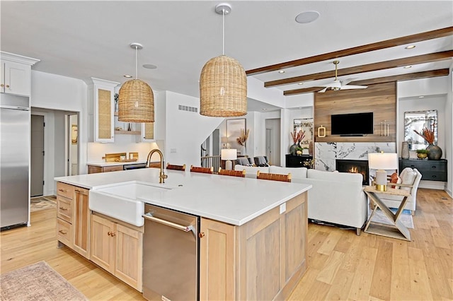 17029 King St, Overland Park, KS 66221 - kitchen with a sink, stainless steel appliances, light wood-style flooring, light brown cabinetry, and a fireplace